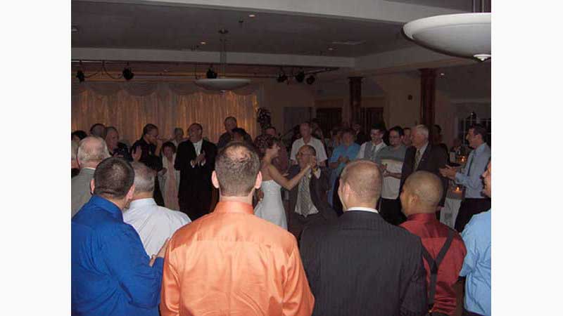 From wedding 4, DJ Ancaster, Bride in lovely white gown dancing with father in law surrounded by guests all in a larger circle around them. Taken in Ancaster Ontario